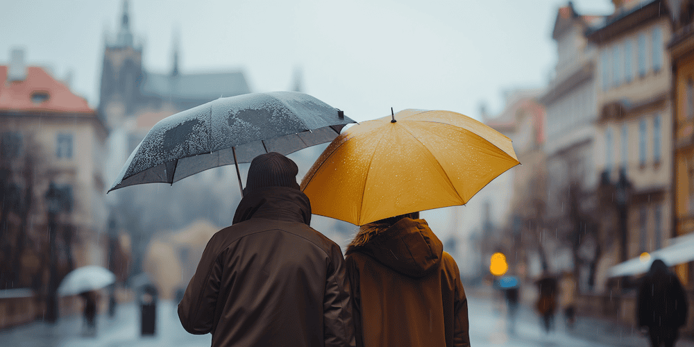 Prag bei Regen: zwei Touristen mit Regenschirm